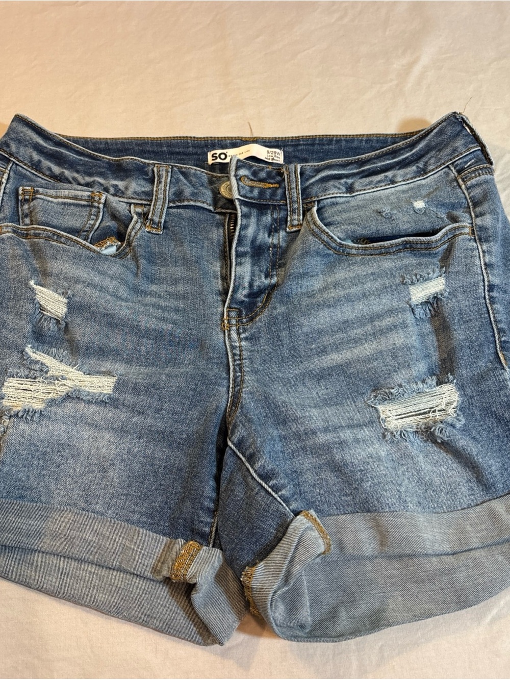 SO Junior Distressed Rolled Hem Denim Shorts in Medium Blue. 656